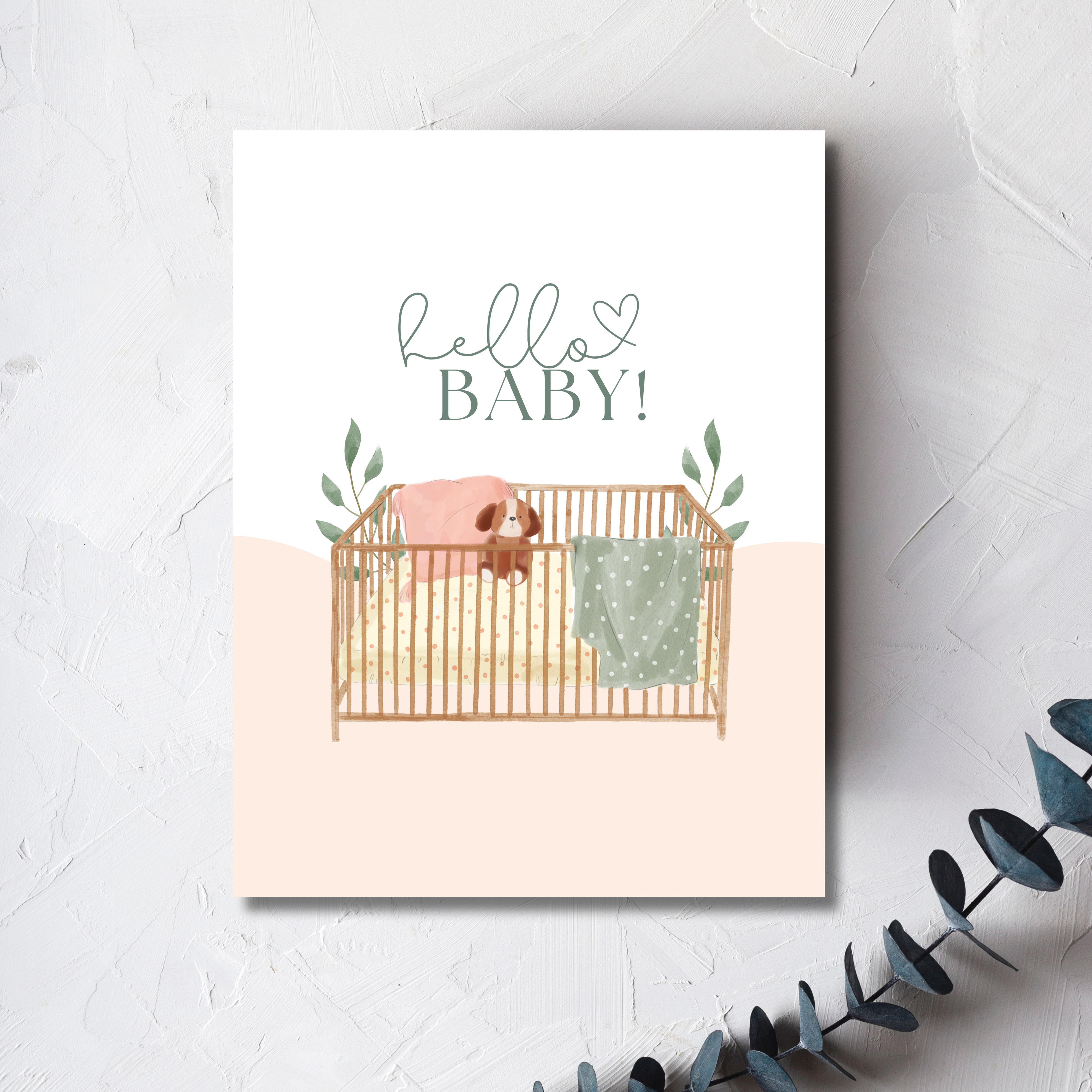 baby crib with fuzzy blankets and stuffed toy animal adorned with leaves, hello baby text with heart written above